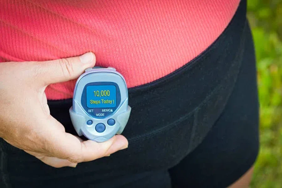 Woman holding a blue pedometer with step count