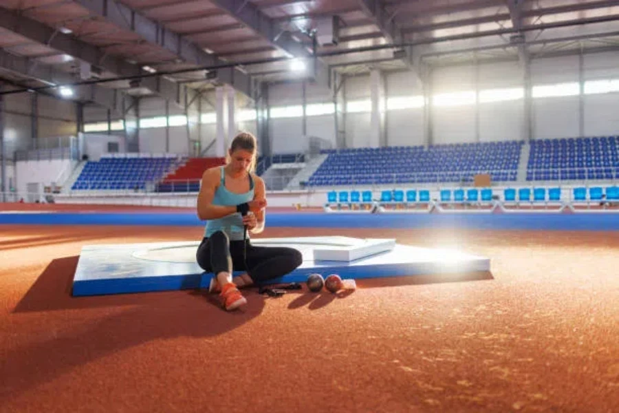 Woman sitting down wearing shot put throwing shoes