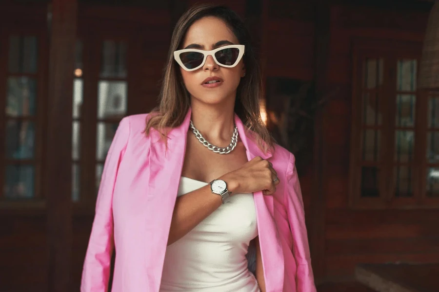 Woman standing in a pink blazer and white dress