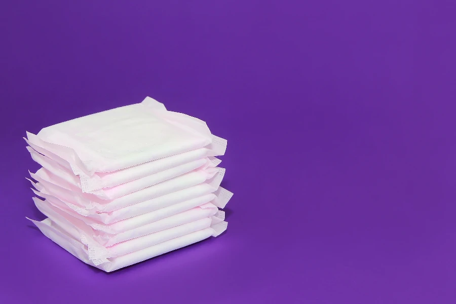 women's white sanitary pads for menstruation on purple background very peri