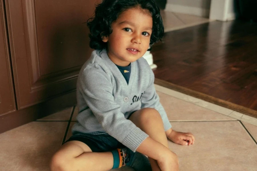 A Little Boy Sitting on the Floor in a House