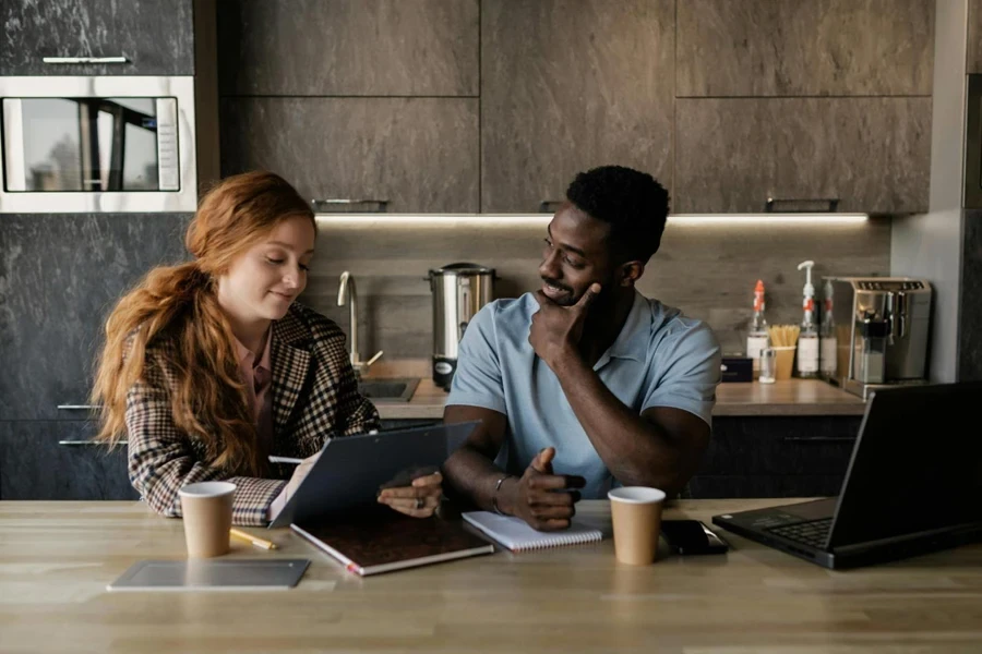 A Man and Woman Having Conversation while Sitting Near the Wooden Table