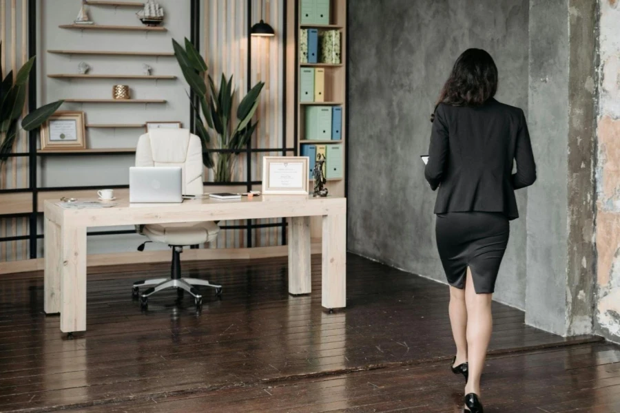 A Woman in a Blazer and a Skirt Walking towards Her Desk