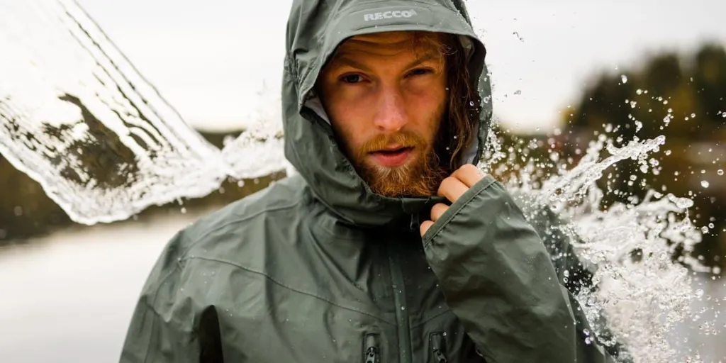 A bearded man in s hooded waterproof jacket