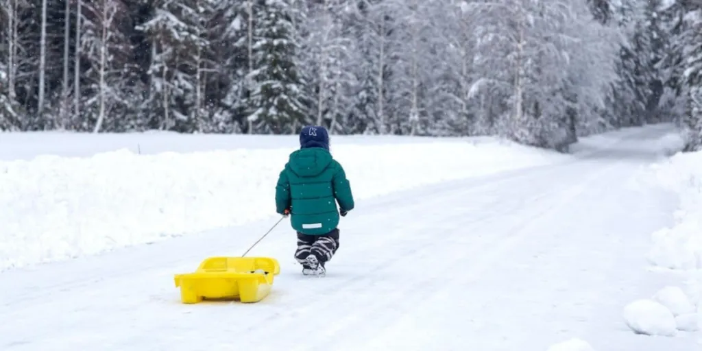 A child in a jacket walking on a snowy road