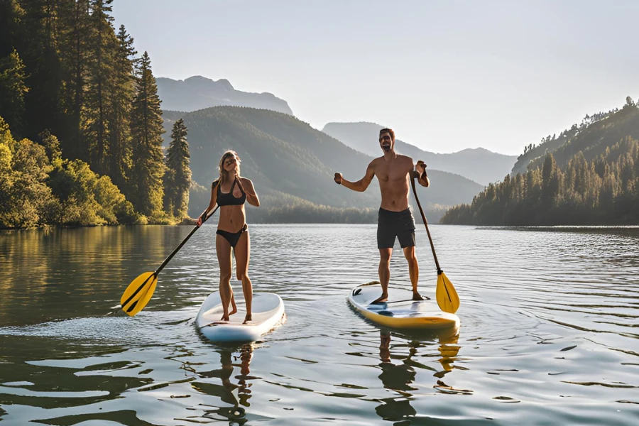 A couple enjoying their time in calm water using two all-around stand-up paddleboards