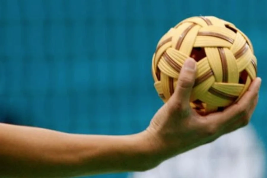 A hand holding a sepak takraw ball