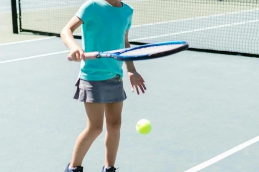 A little girl playing with a tennis ball