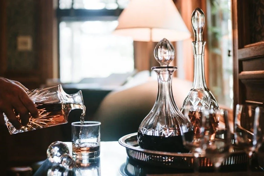 A person pouring down liquid from decanter