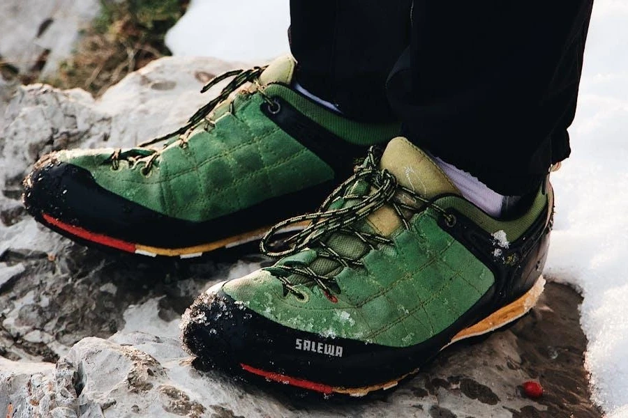 A person standing in a green hiking shoe