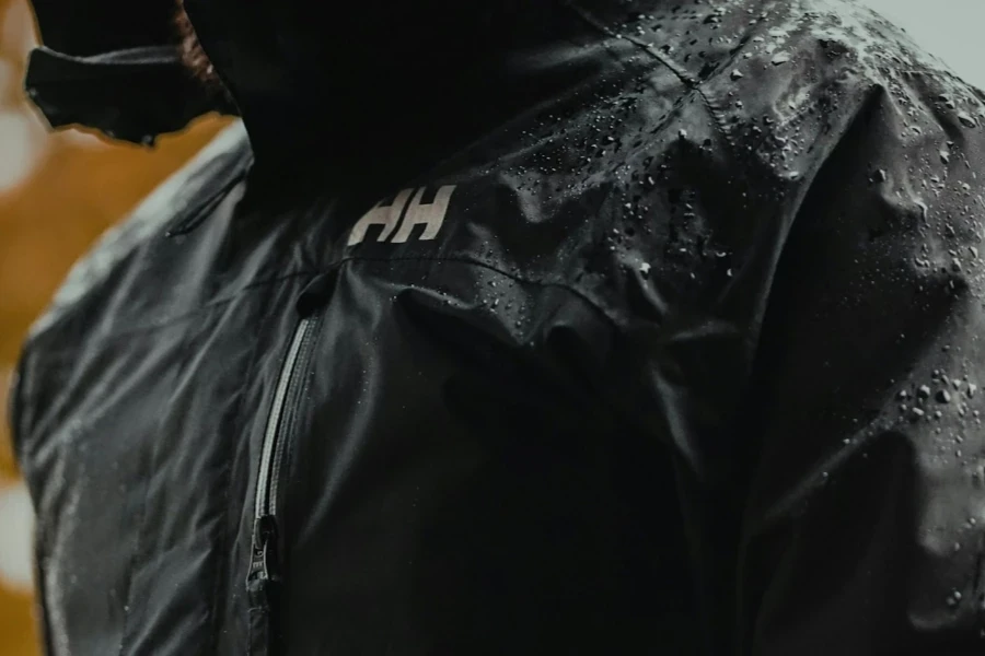 A person wearing a wet black rain jacket