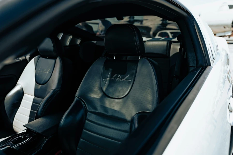 A white car with black leather seats in a parking lot