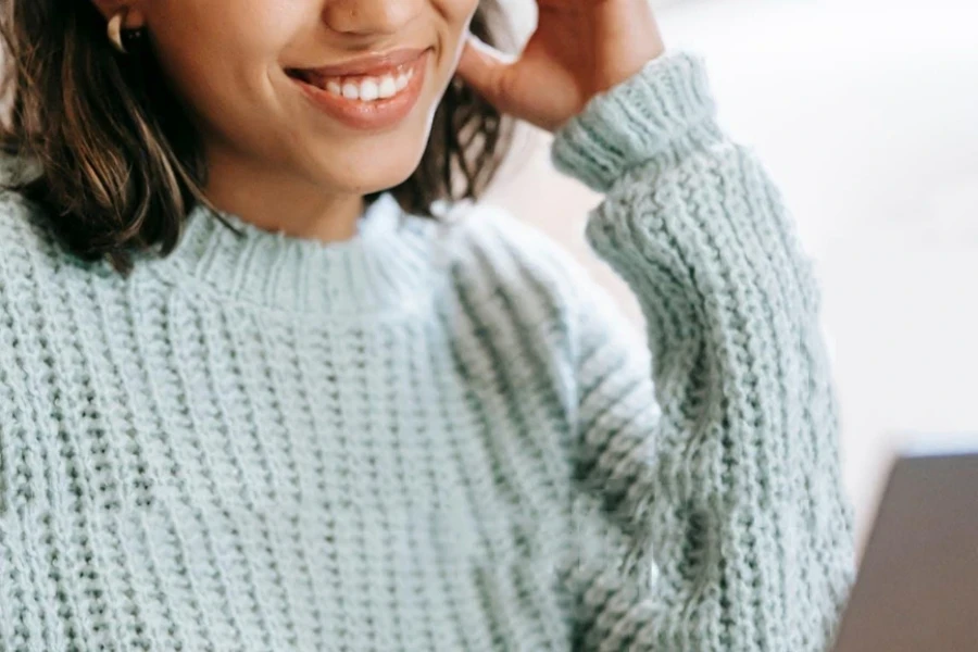 A woman smiling while looking at her laptop