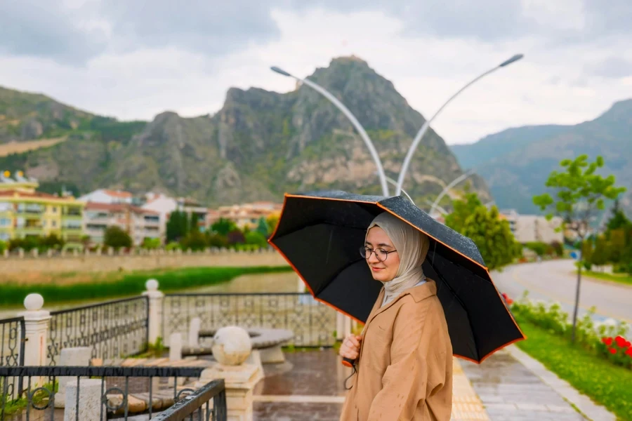 A woman with an umbrella standing in front of a building