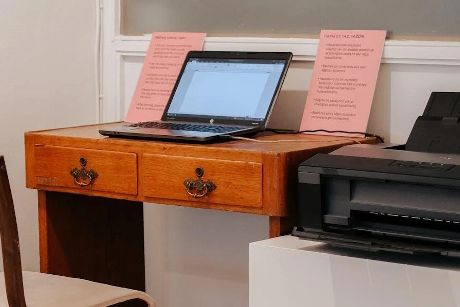 A workspace with a laptop and black printer