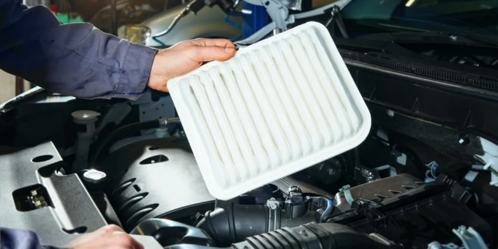 Auto mechanic replacing an air filter