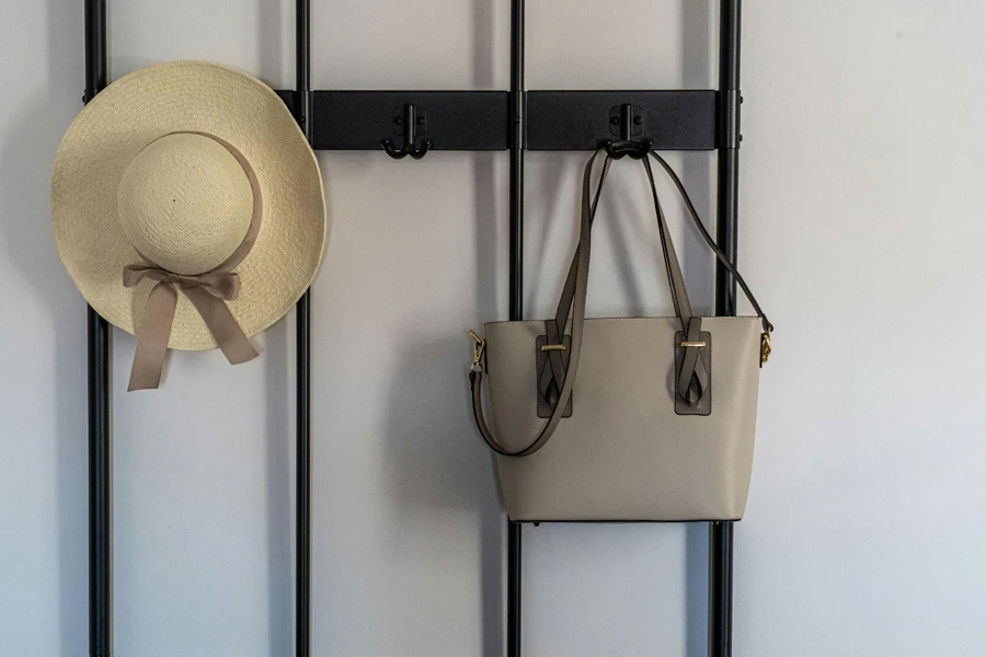 Black Metal Hook Hanging a Beige Hat and Grey Sling Bag