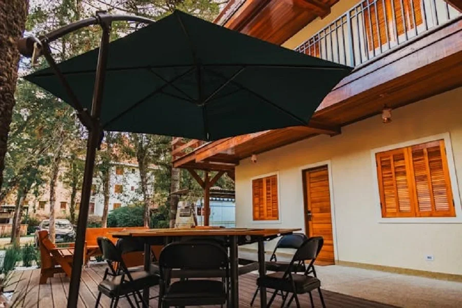 Black patio umbrella over table and chairs