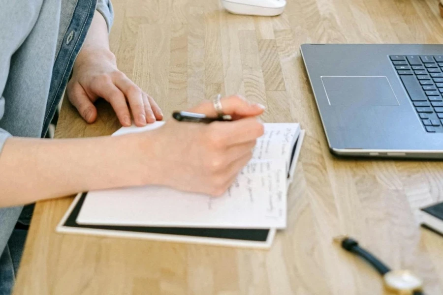 Blogger in jean jacket writing on paper