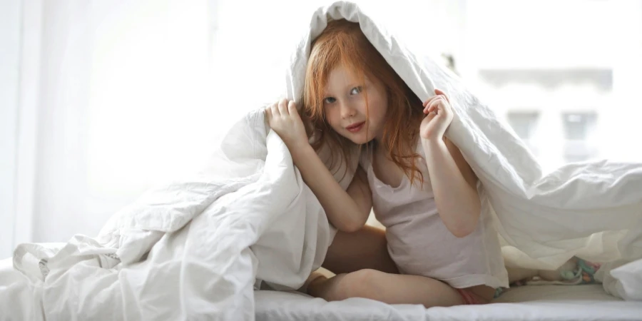 Child Covering Her Body In A White Comforter