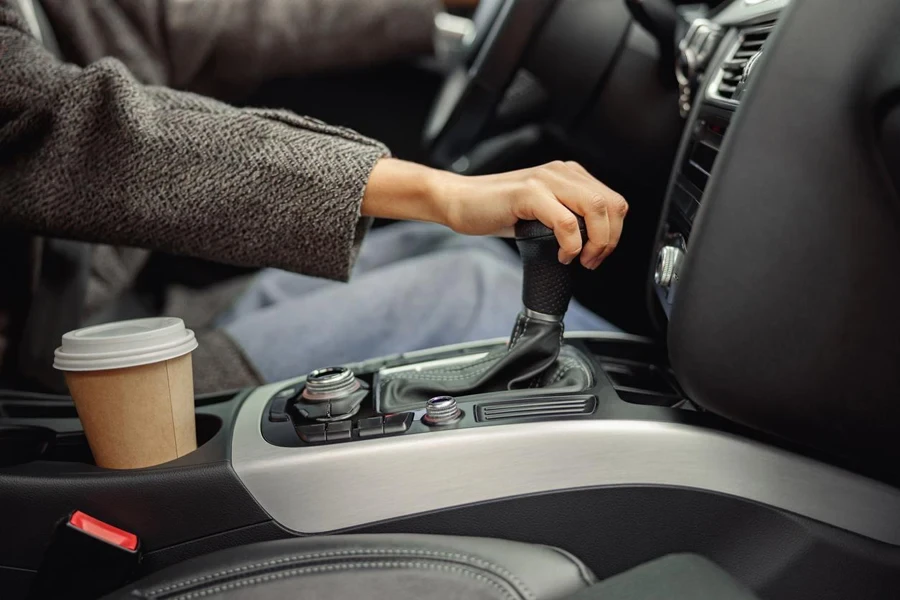 Close up of woman change speed holding hand on gearbox in the car