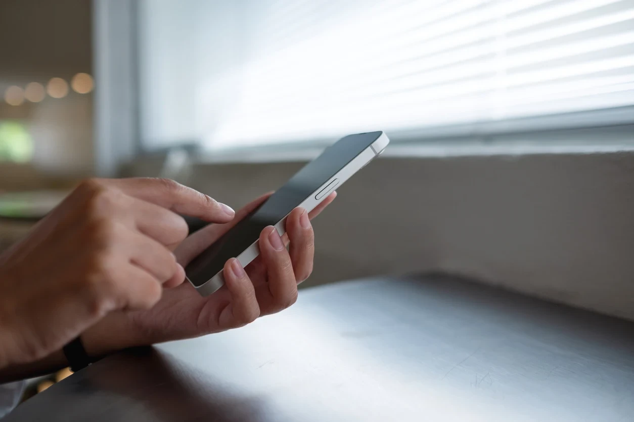 Closeup image of a woman using and touching on mobile phone