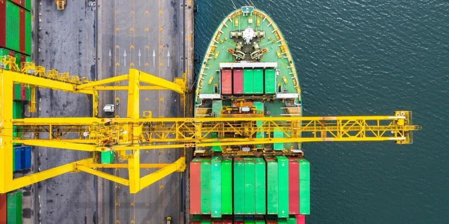 Container ship loading and unloading in deep sea port, Aerial top view of business logistic import and export freight transportation by container ship in open sea.