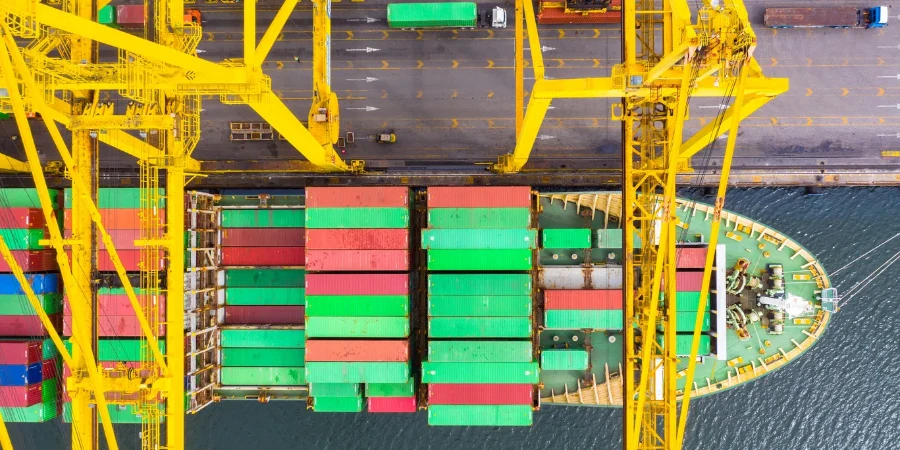 Container ship loading and unloading in deep sea port, Aerial top view of business logistic import and export freight transportation by container ship in open sea.