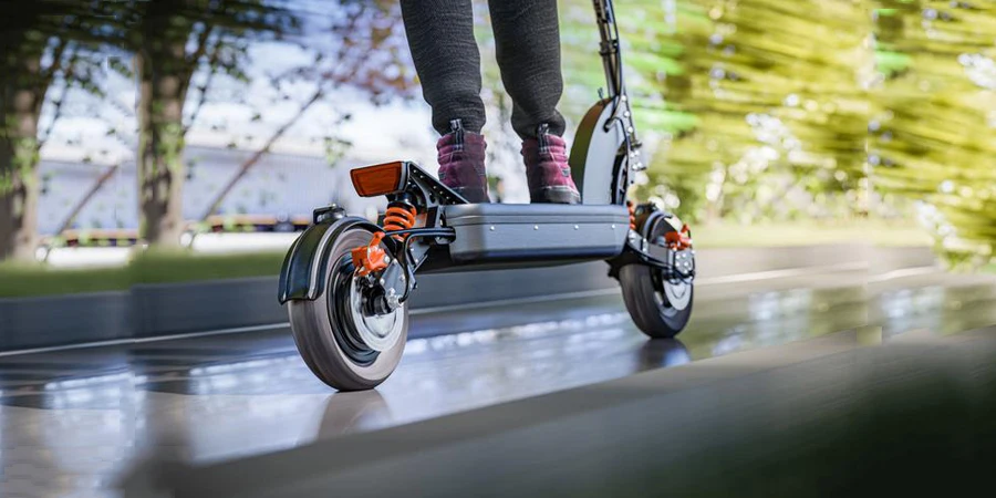 Electric scooter fast ride through the city - closeup to back wheel, motion blur effect