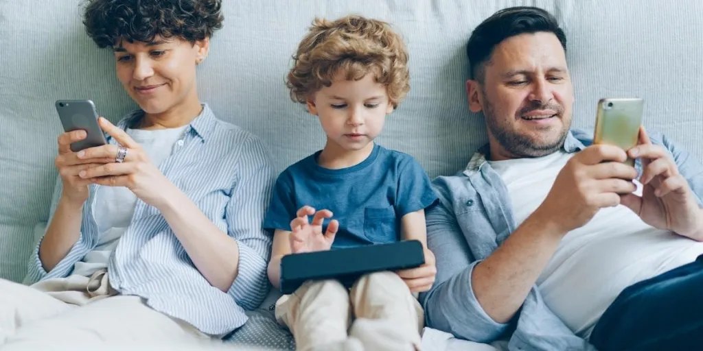 Family on couch, each person using a different mobile device