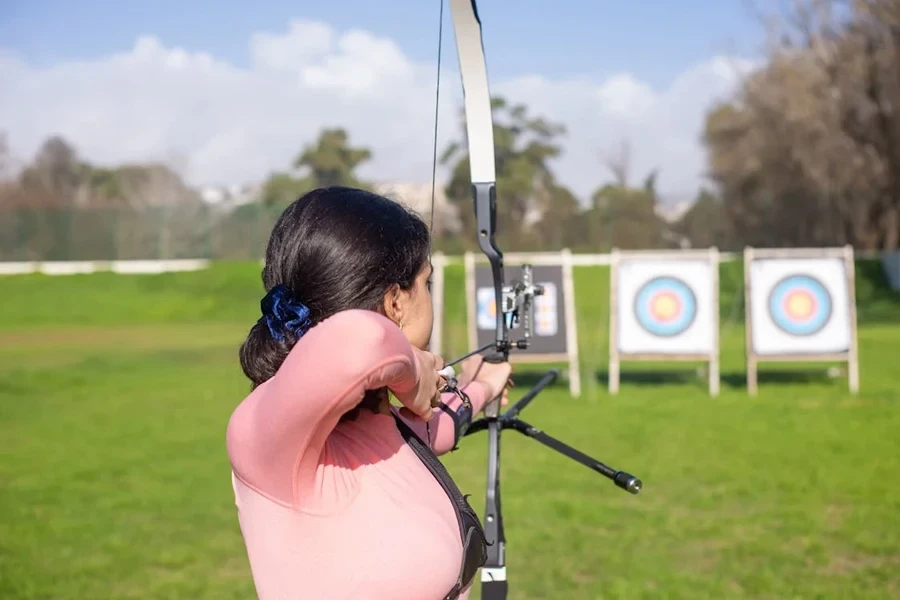 Female archer lining up target using wrist strap release