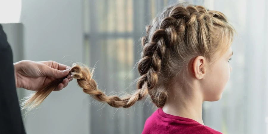 Hairdresser Weaves a Braid on a Teenage Blonde Girl