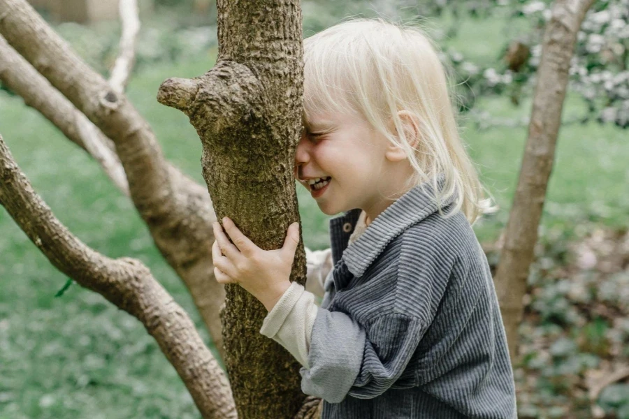 Happy little boy standing near trunk