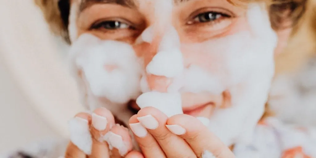 Happy woman using face wash