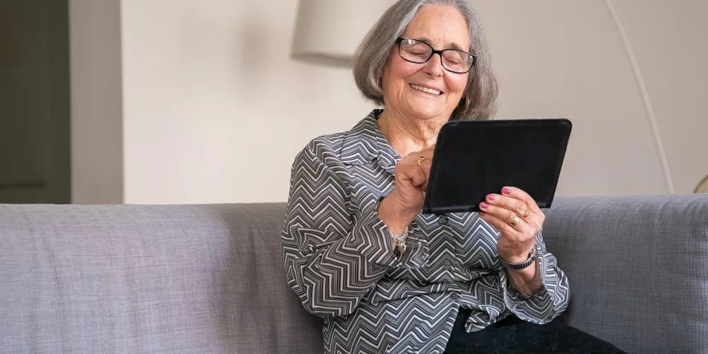 Signora sorridente mentre usa il suo tablet