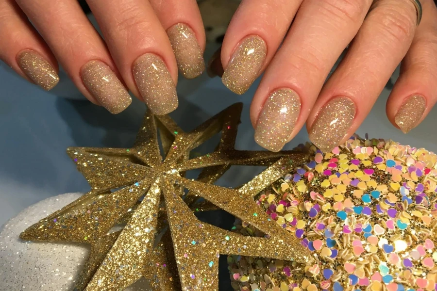 Lady wearing gold glitter nails