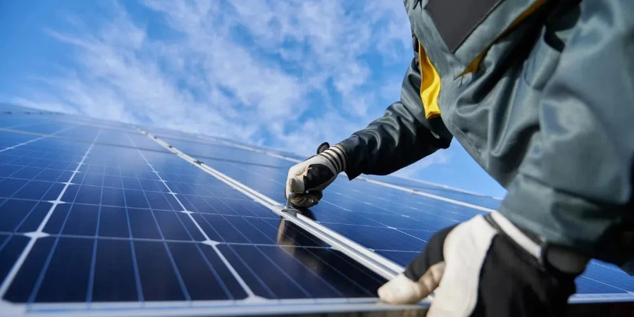 Male worker repairing photovoltaic solar panel.