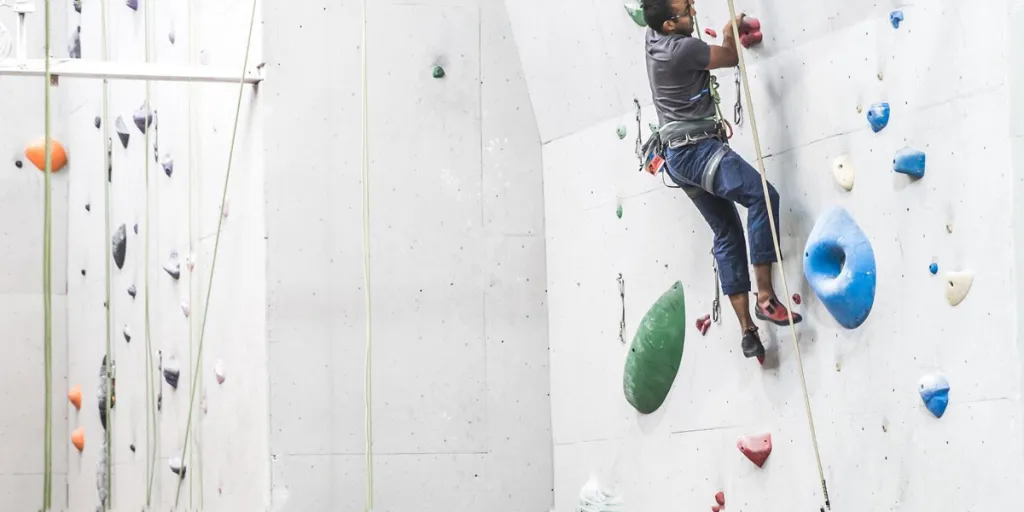 Man bouldering while wearing a climbing harness