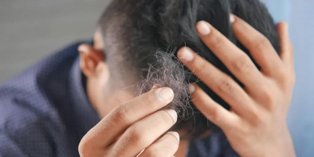 Man holding strands of his hair