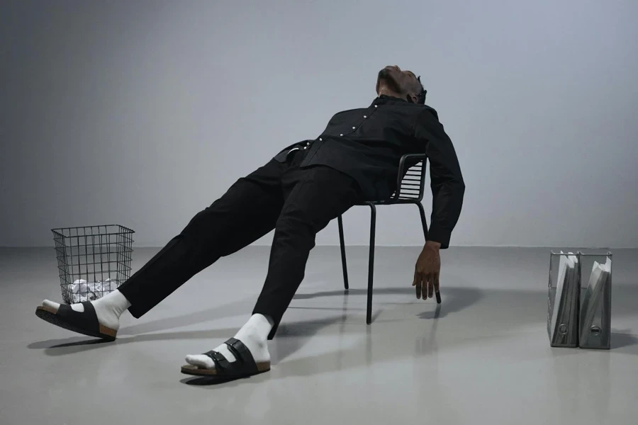 Man in Black Long Sleeves and Pants Lying Down on Chair