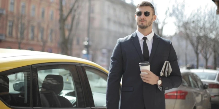 Man in Black Suit Standing Beside Yellow Car