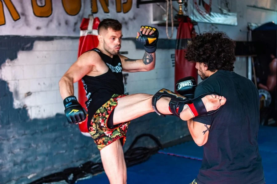 Man wearing colorful shorts practicing kickboxing