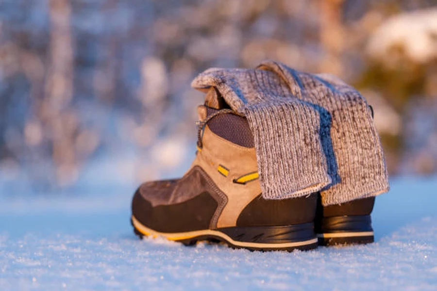 Pair of hiking socks on top of boots in snow