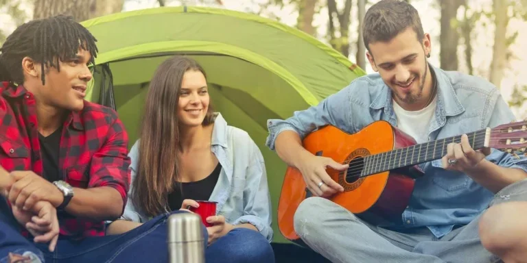 People sitting outside a green camping tent