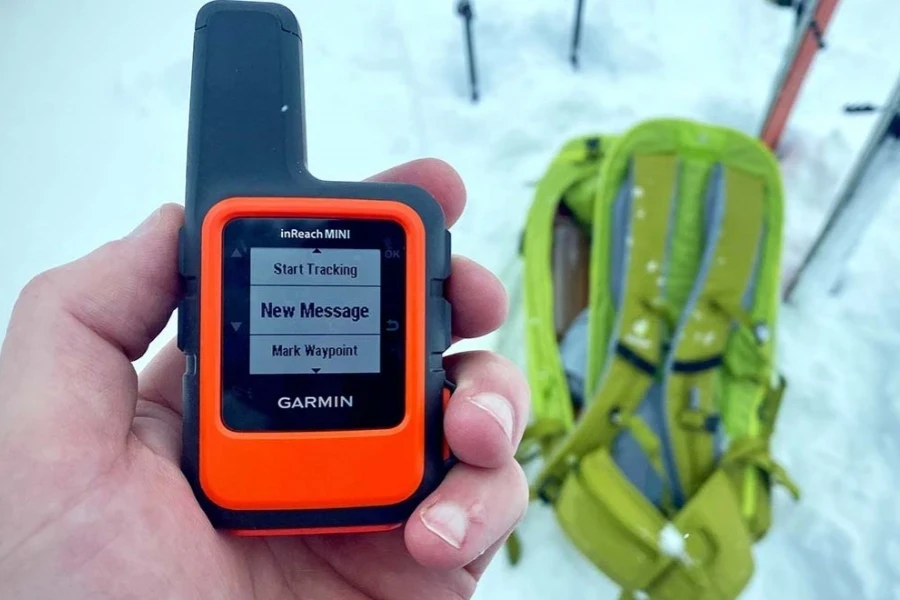 Person hiking with a handheld GPS unit with satellite communication