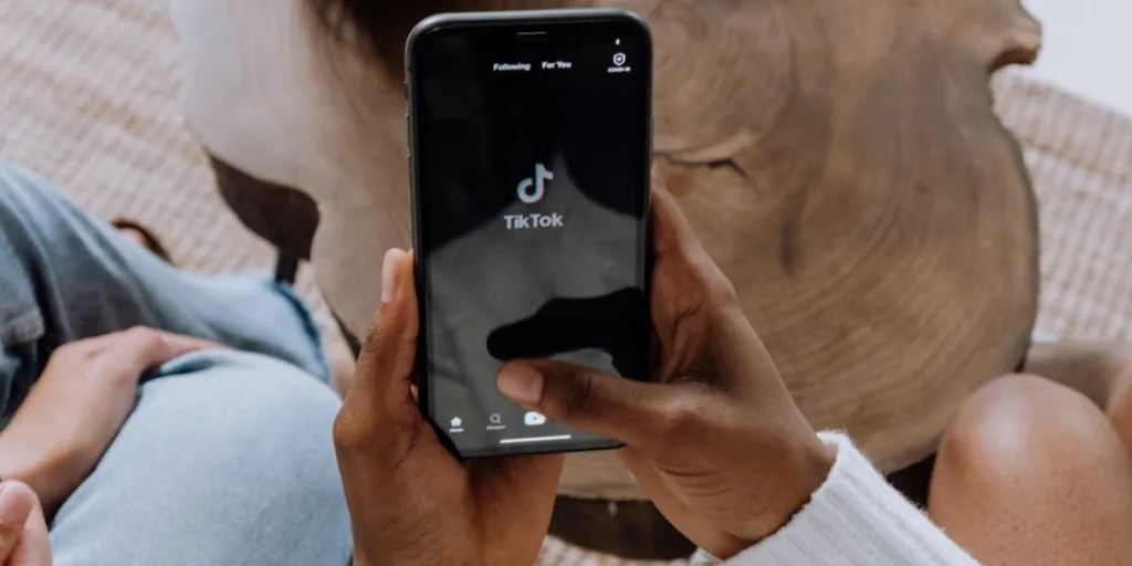 Person holding smartphone with the TikTok symbol on the screen