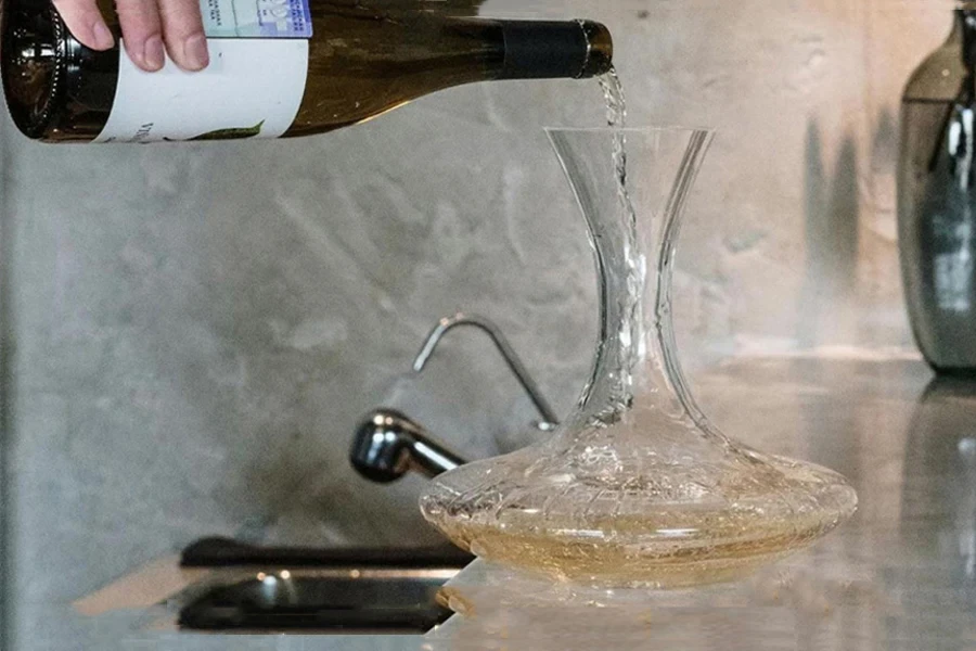 Person pouring wine into a decanter