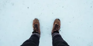 Person standing in the snow with boots and winter socks