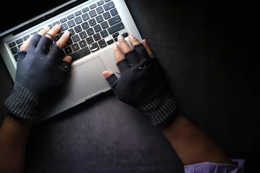 Person using a laptop with gloves on