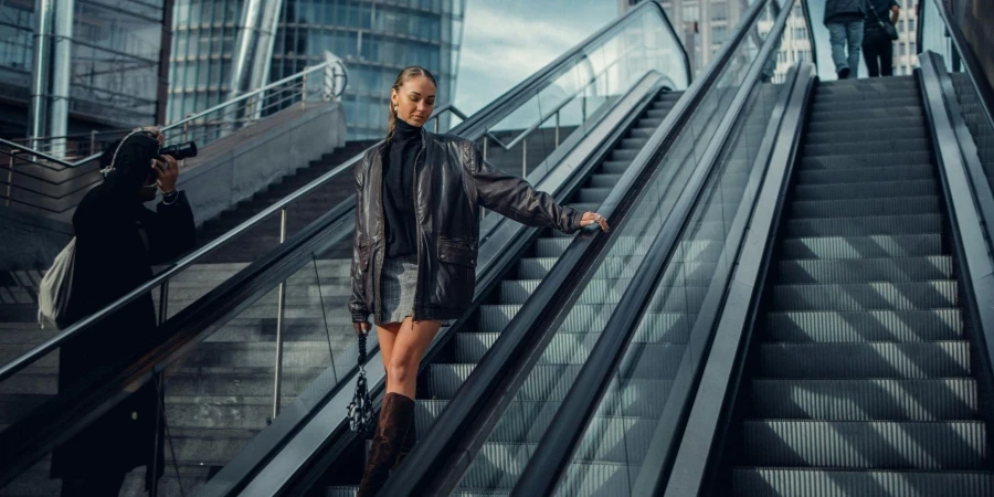 Pretty Brunette Woman in Leather Jacket Posing on Escalator